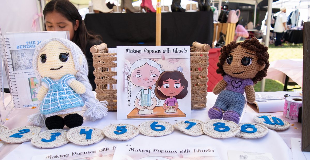 Making Pupusas with Abuela displayed at an event with handmade crochet dolls of the characters