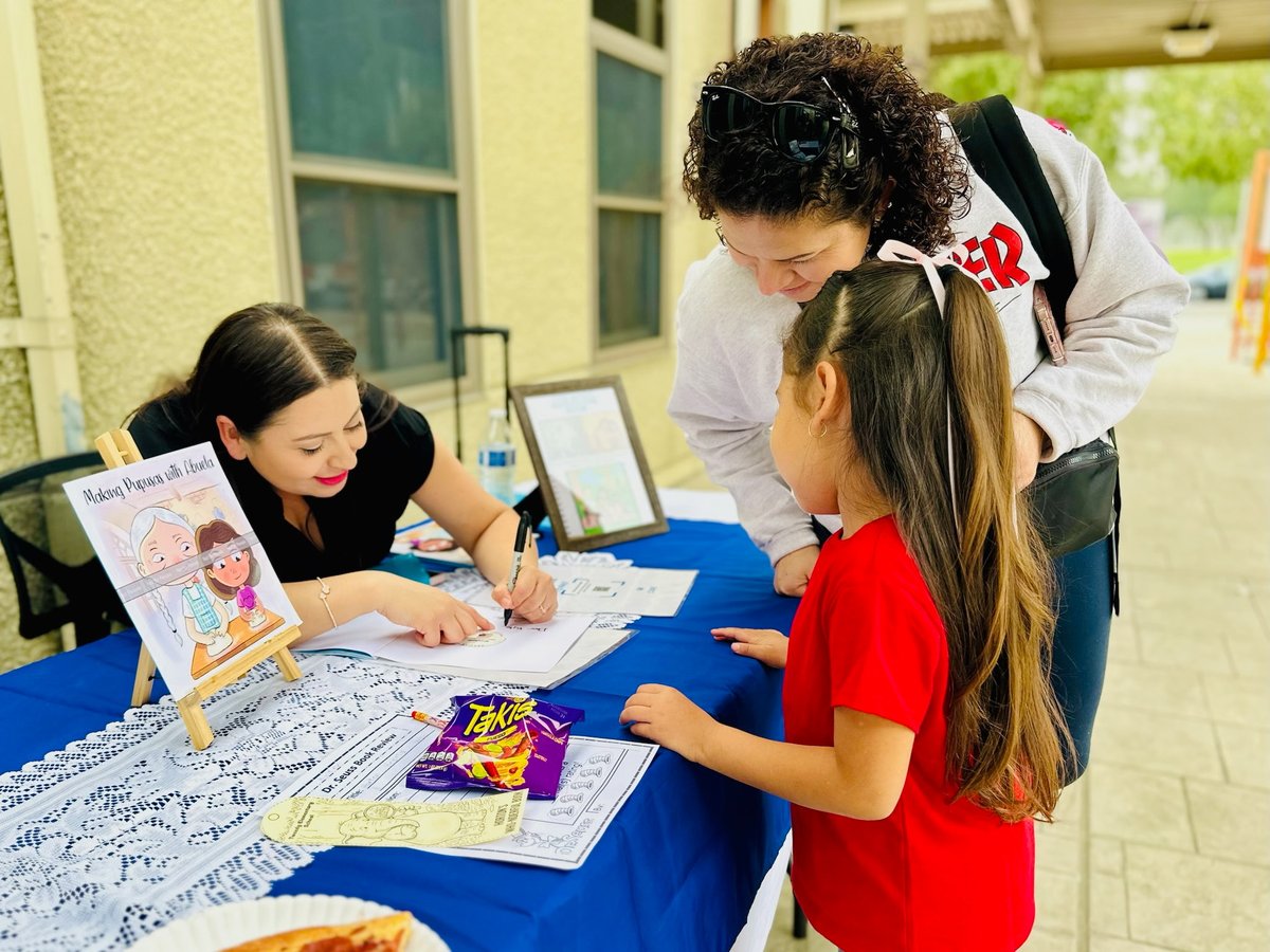 Denise signing a copy of her book for a young reader at a school event