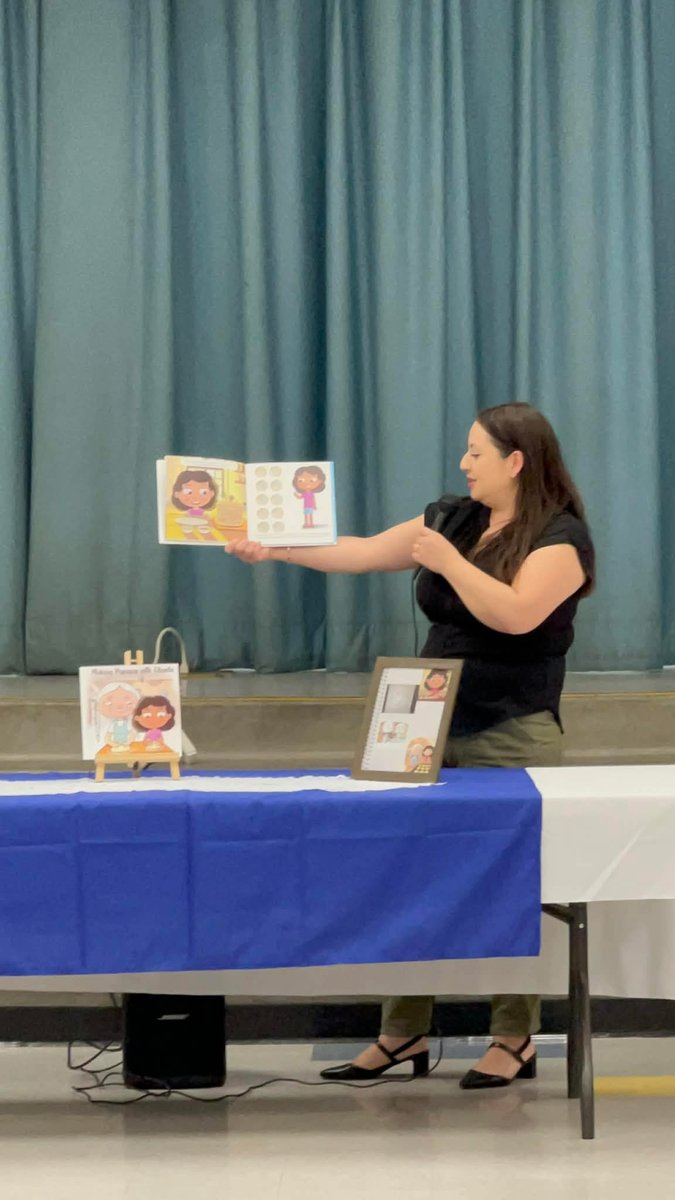 Denise reading Making Pupusas with Abuela to students at a school assembly